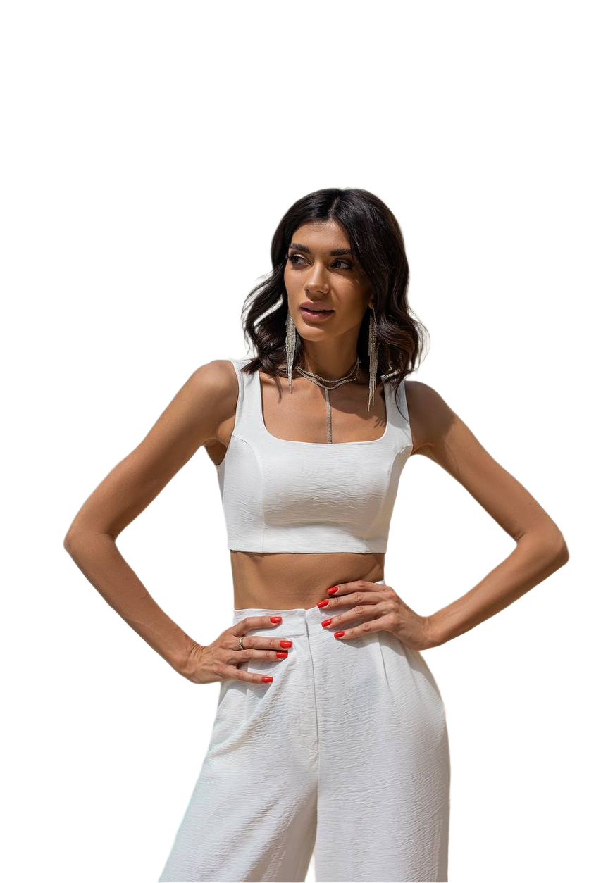 Woman wearing a white crop top and pants on a white background