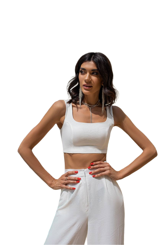 Woman wearing a white crop top and pants on a white background