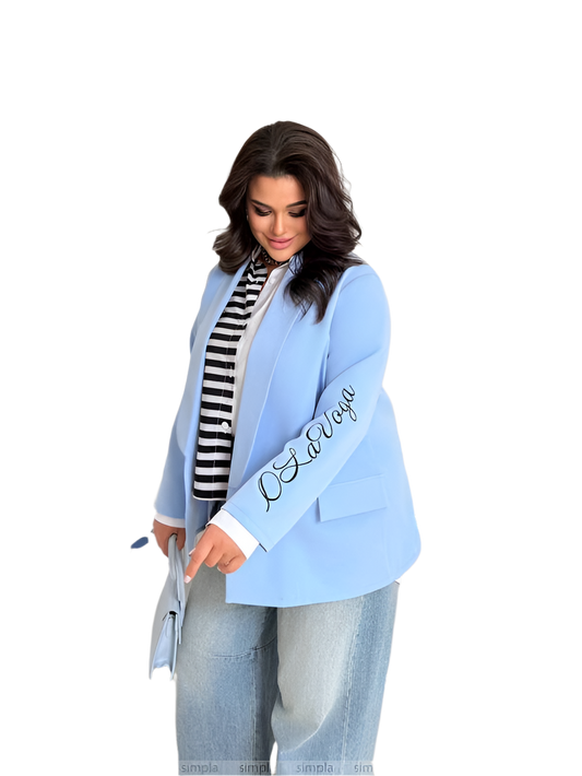Woman wearing a light blue blazer with 'LOVE' embroidered on the sleeve against a white background