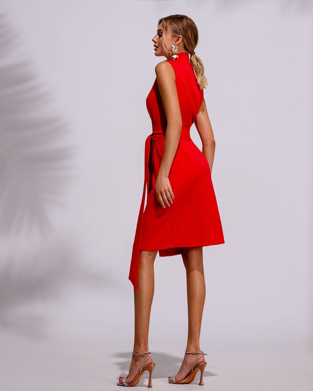 Woman wearing a red dress with a plain background