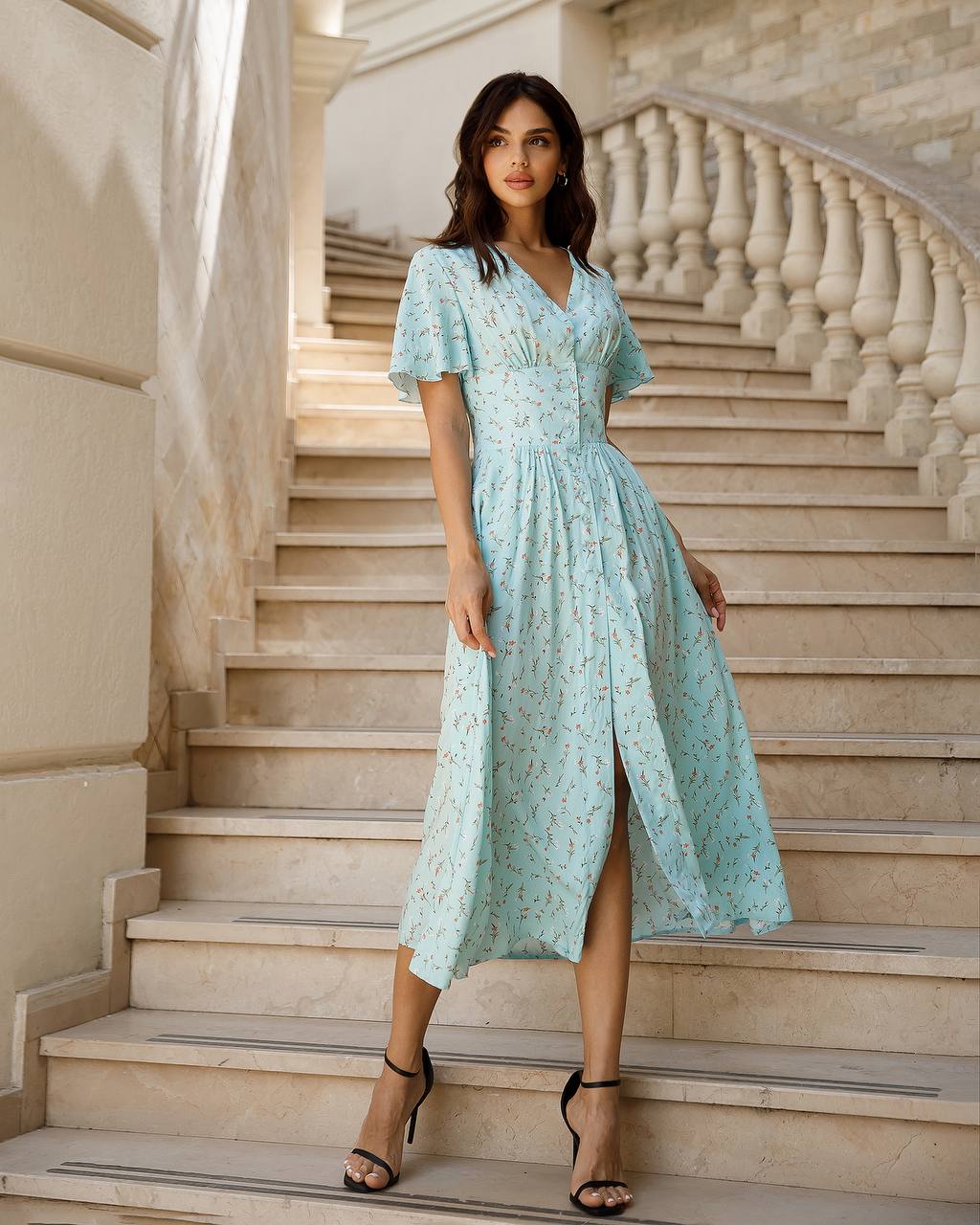 Woman in a light blue dress standing on stone steps