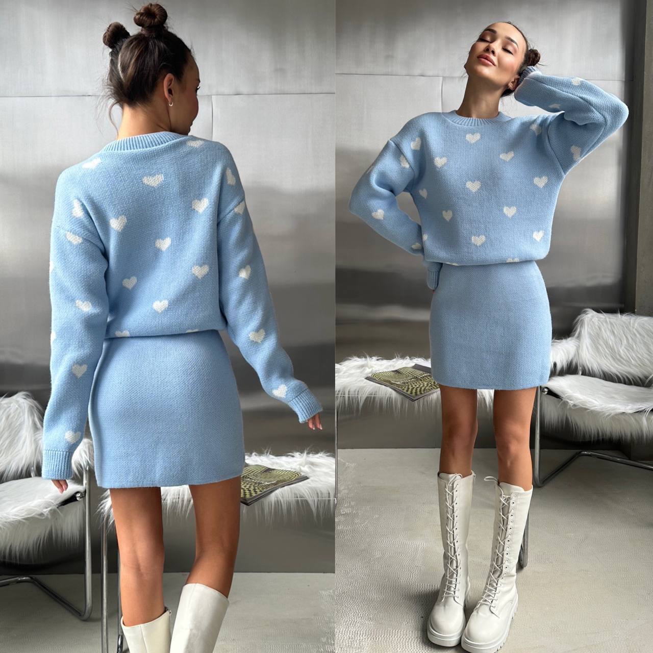 Woman wearing a light blue sweater and skirt set with heart patterns, standing in a room.