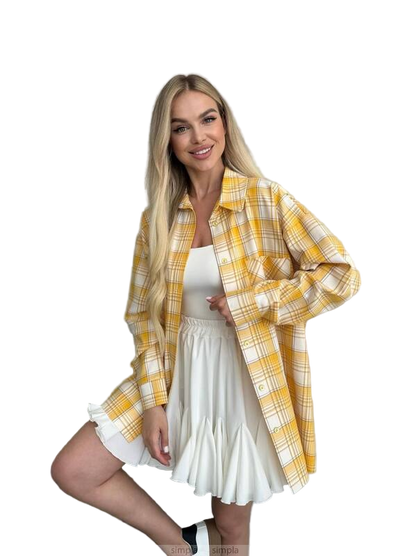 Woman wearing a yellow plaid shirt over a white dress on a white background
