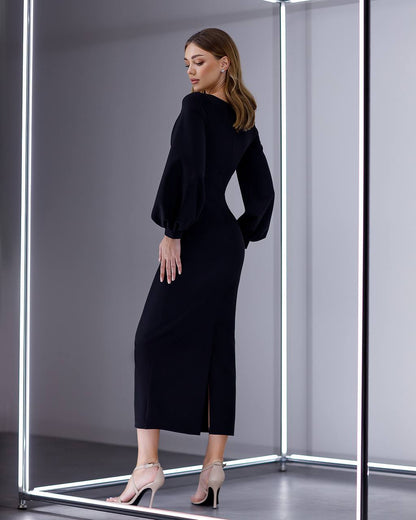 Woman wearing a black dress in a modern fitting room with reflective floor.