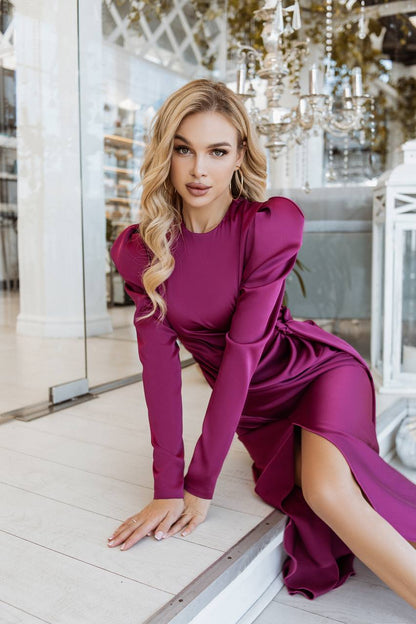 Woman in a magenta dress posing indoors with decorative elements in the background