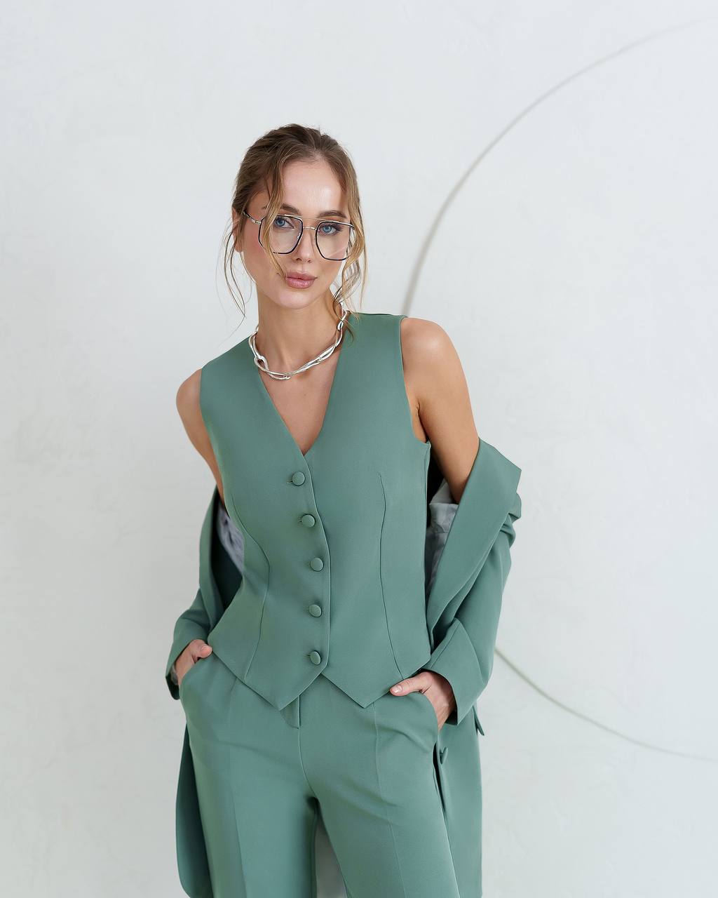 Woman wearing a green suit with a white background