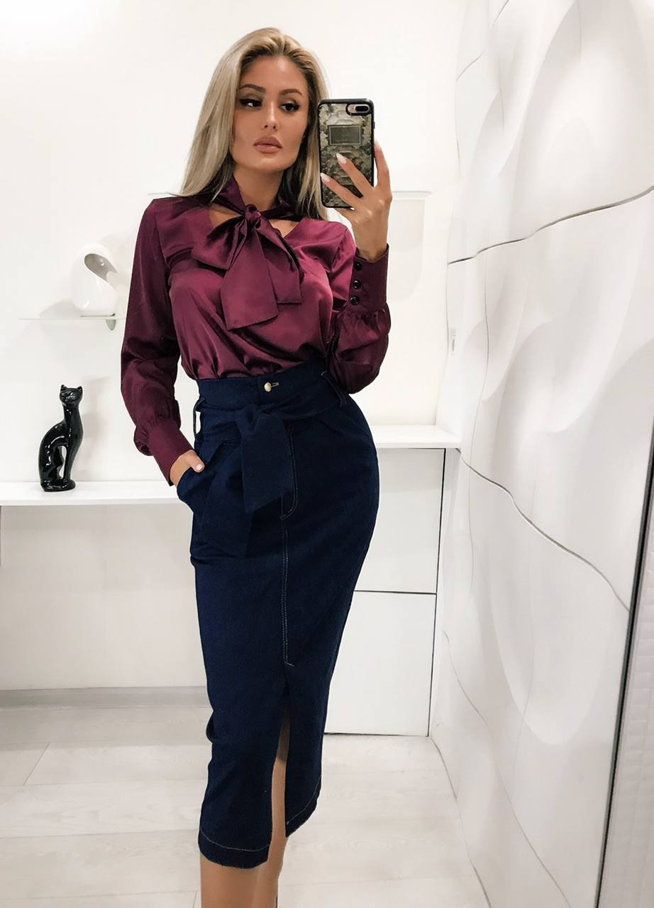 Woman taking a mirror selfie wearing a burgundy blouse and navy skirt in a bathroom.