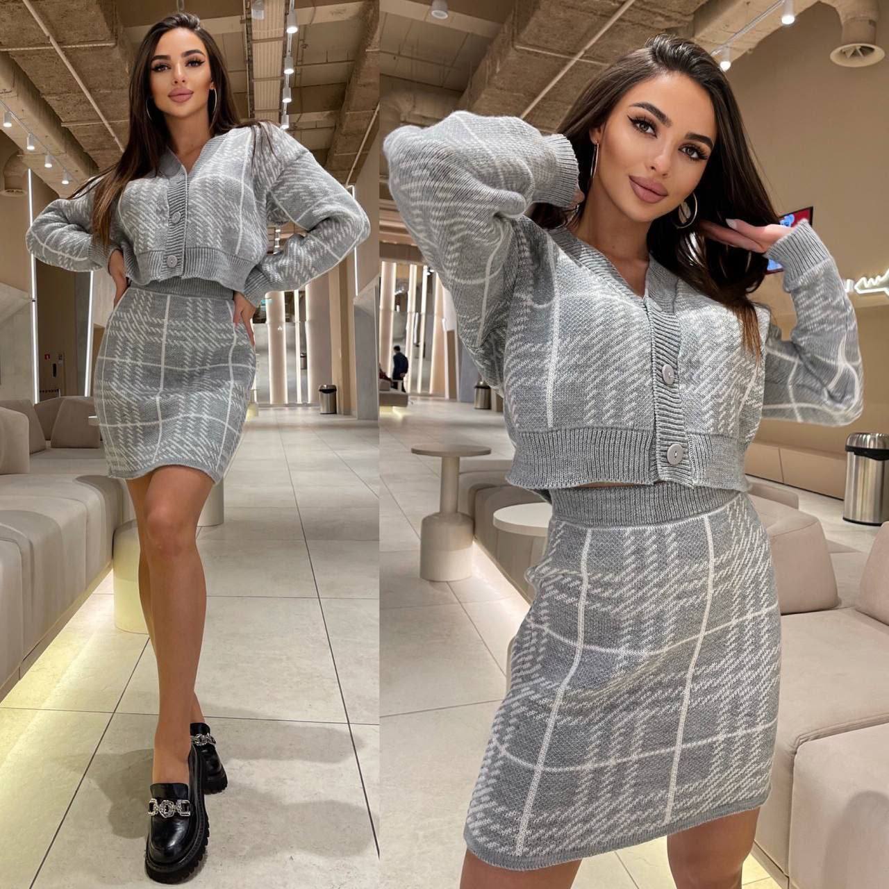 Woman wearing a gray checkered outfit in a modern indoor setting