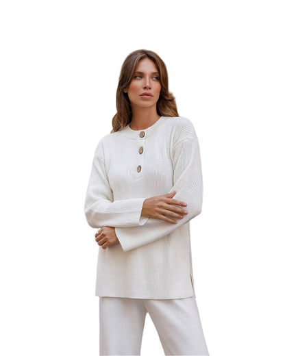 Woman wearing a white ribbed sweater with button details on a white background