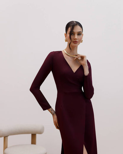 Woman wearing a burgundy dress with a plain background