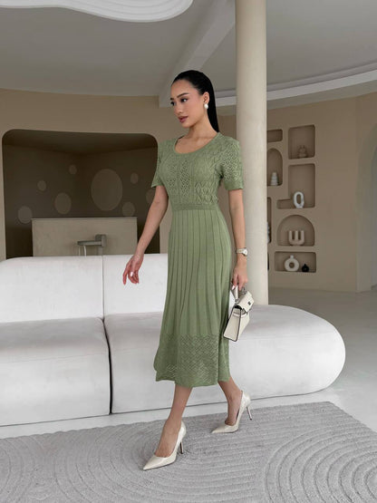 Woman in a green dress standing in a modern interior setting