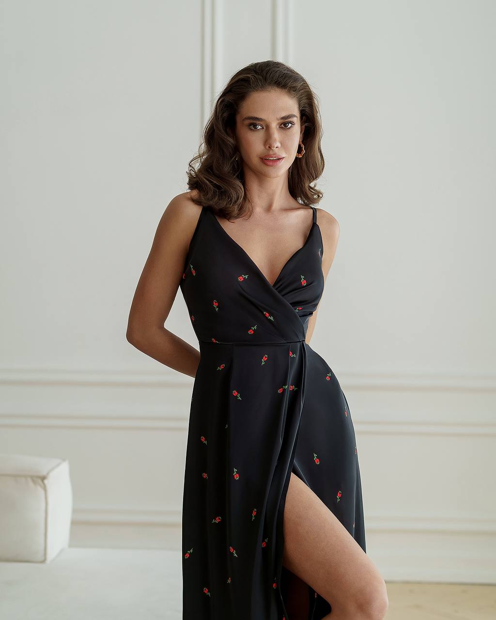 Woman wearing a black dress with a pattern in an indoor setting