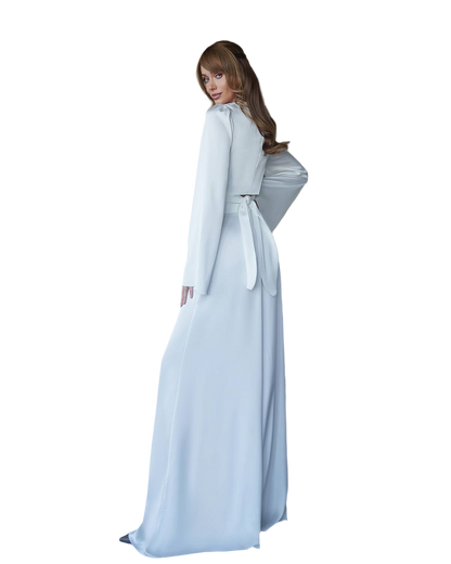 Person wearing a light blue dress with a cape on a white background