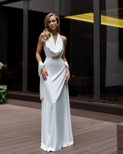 Woman in a white dress standing on a wooden deck with a building in the background