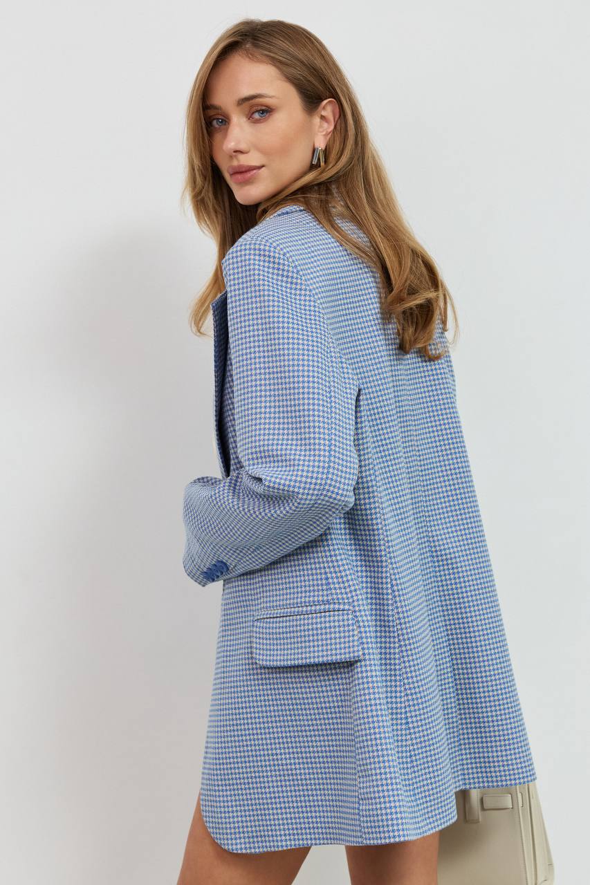 Woman wearing a blue checkered blazer against a white background