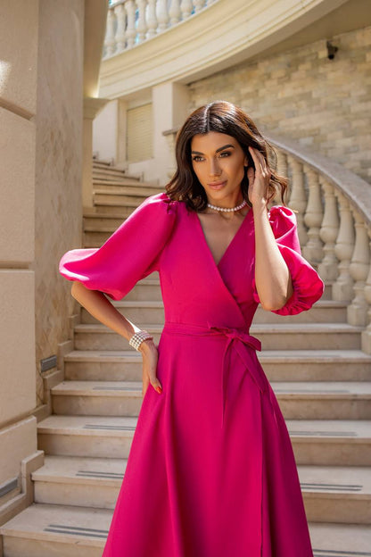 Woman in a pink dress standing on a staircase
