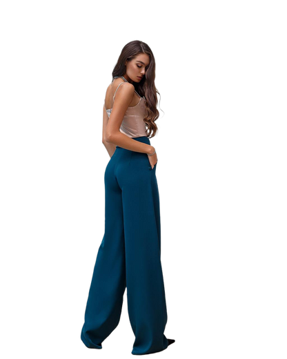 Woman wearing teal wide-leg pants on a white background