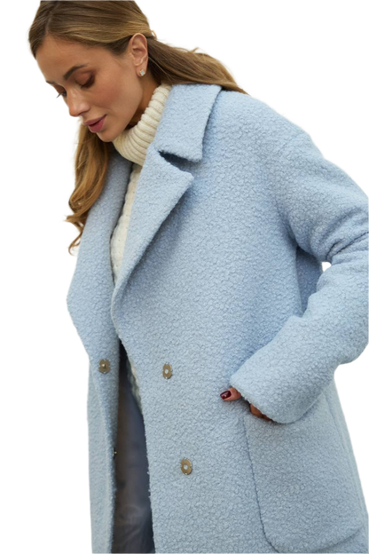 Woman wearing a light blue coat on a white background