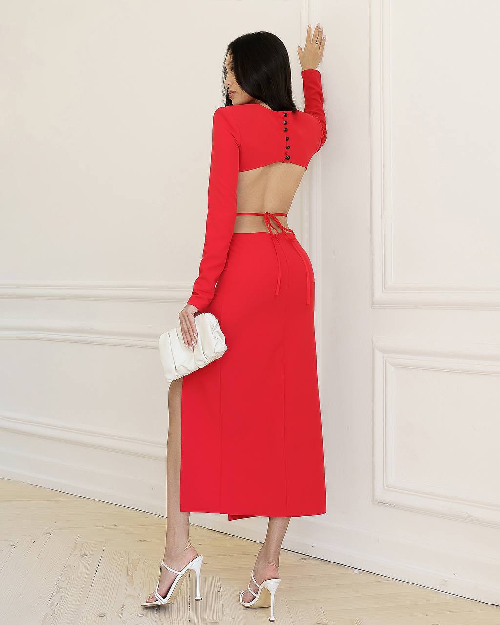 Woman wearing a red outfit with a white wall background