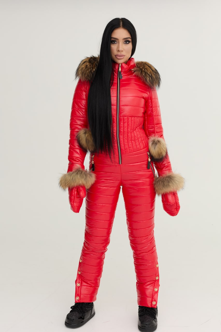Person wearing a red puffer jumpsuit with fur trim on a white background
