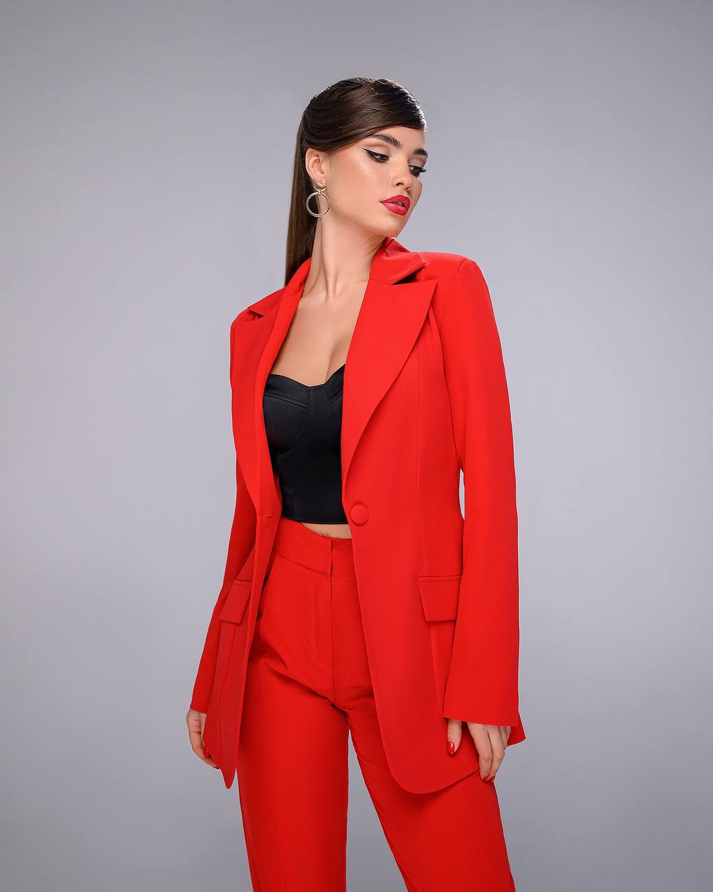 Woman wearing a red suit against a gray background