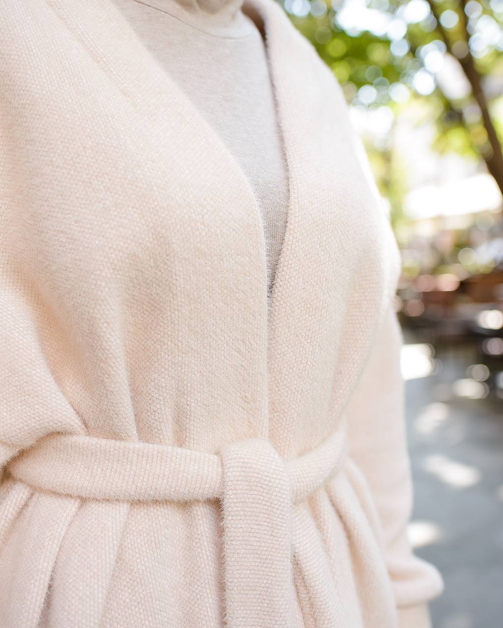 Close-up of a beige robe with a blurred outdoor background