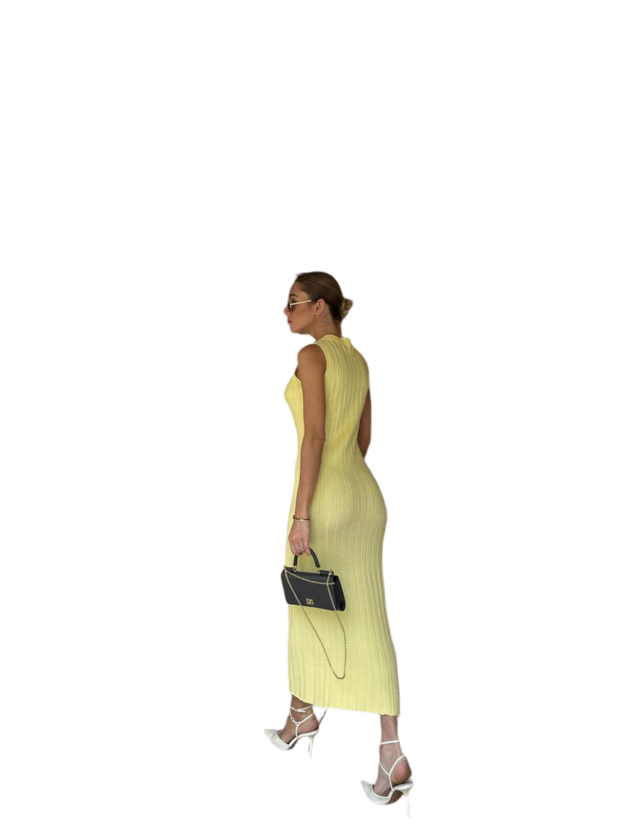 Woman wearing a yellow dress holding a black handbag on a white background
