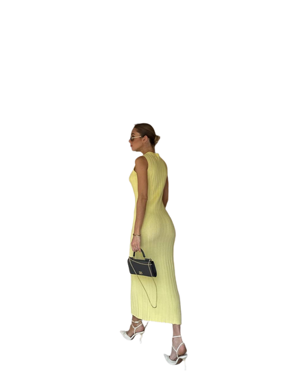 Woman wearing a yellow dress holding a black handbag on a white background
