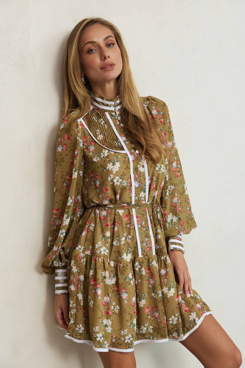 Woman wearing a floral dress against a plain background