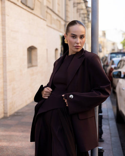 Woman wearing a dark brown coat on a city street