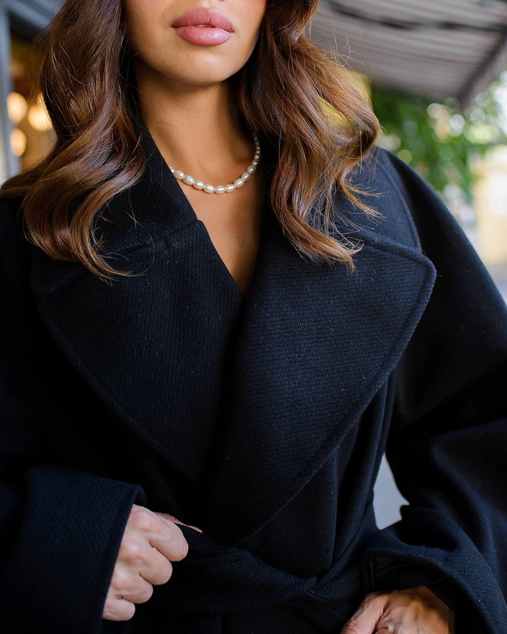 Woman wearing a dark coat with a blurred background