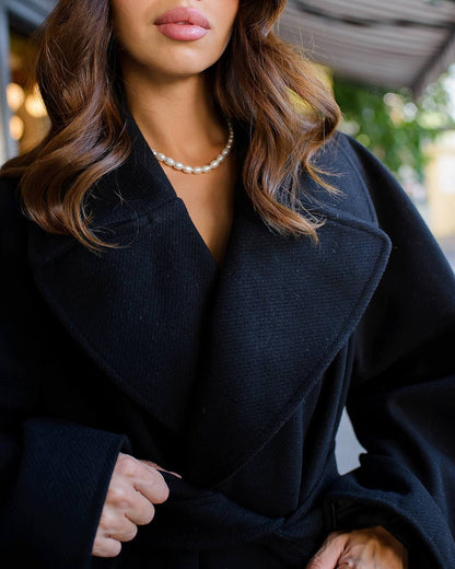 Woman wearing a dark coat with a blurred background