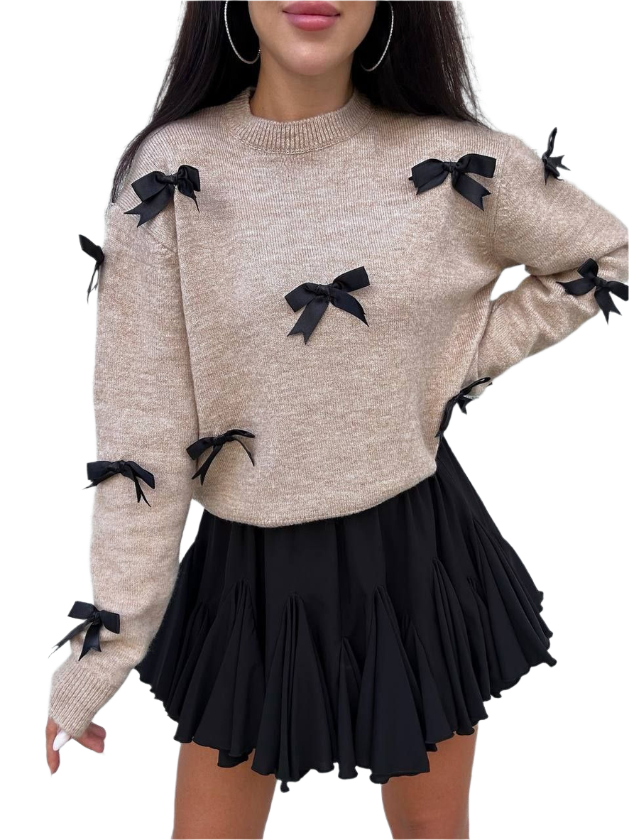 Beige sweater with black bows and a black skirt on a white background