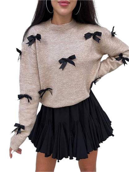 Beige sweater with black bows and a black skirt on a white background