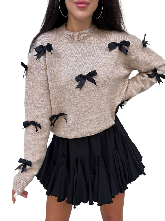 Beige sweater with black bows and a black skirt on a white background