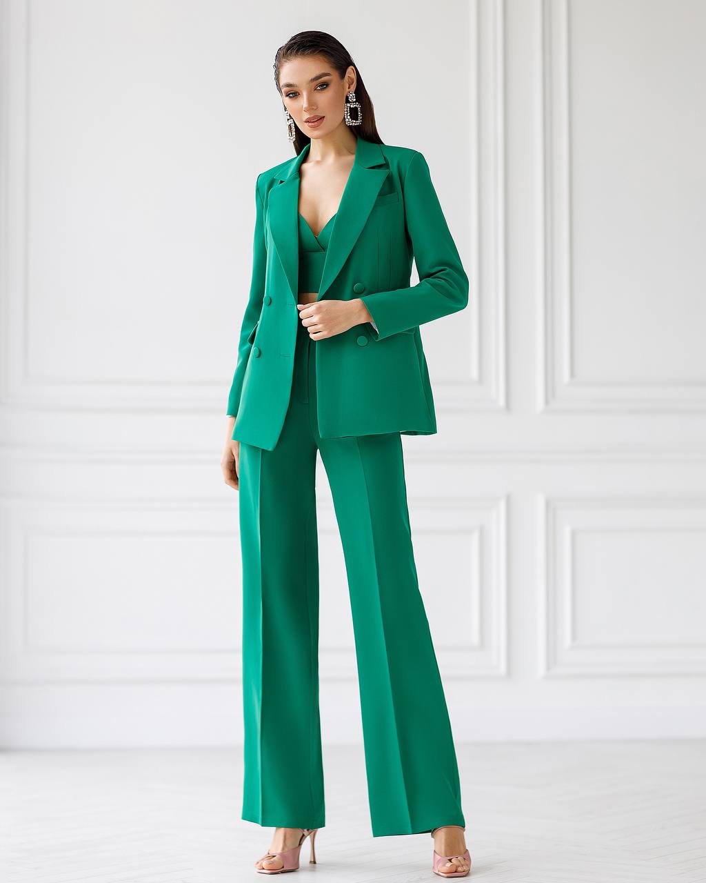 Woman wearing a green suit against a white background