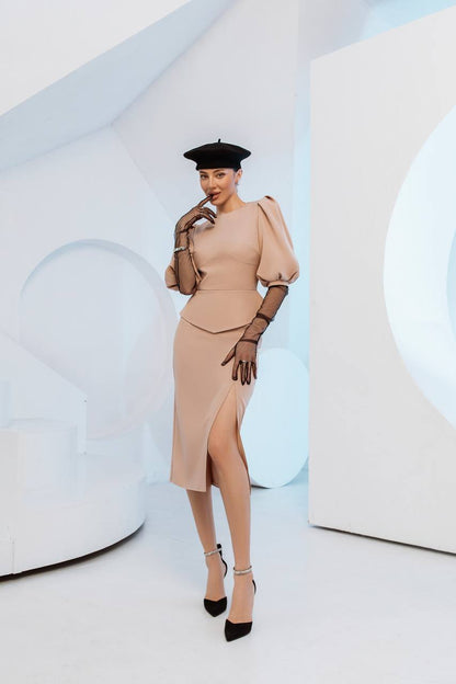 Woman in a beige dress with puffed sleeves and a black hat against a white background