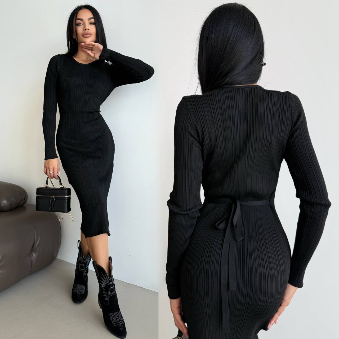 Woman wearing a black ribbed dress with long sleeves and a belt, holding a matching handbag.