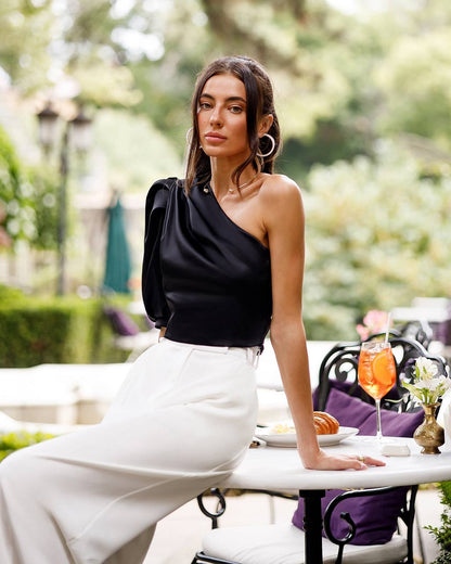 Woman sitting at an outdoor table with a scenic background