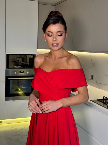 Woman in a red dress standing in a modern kitchen.
