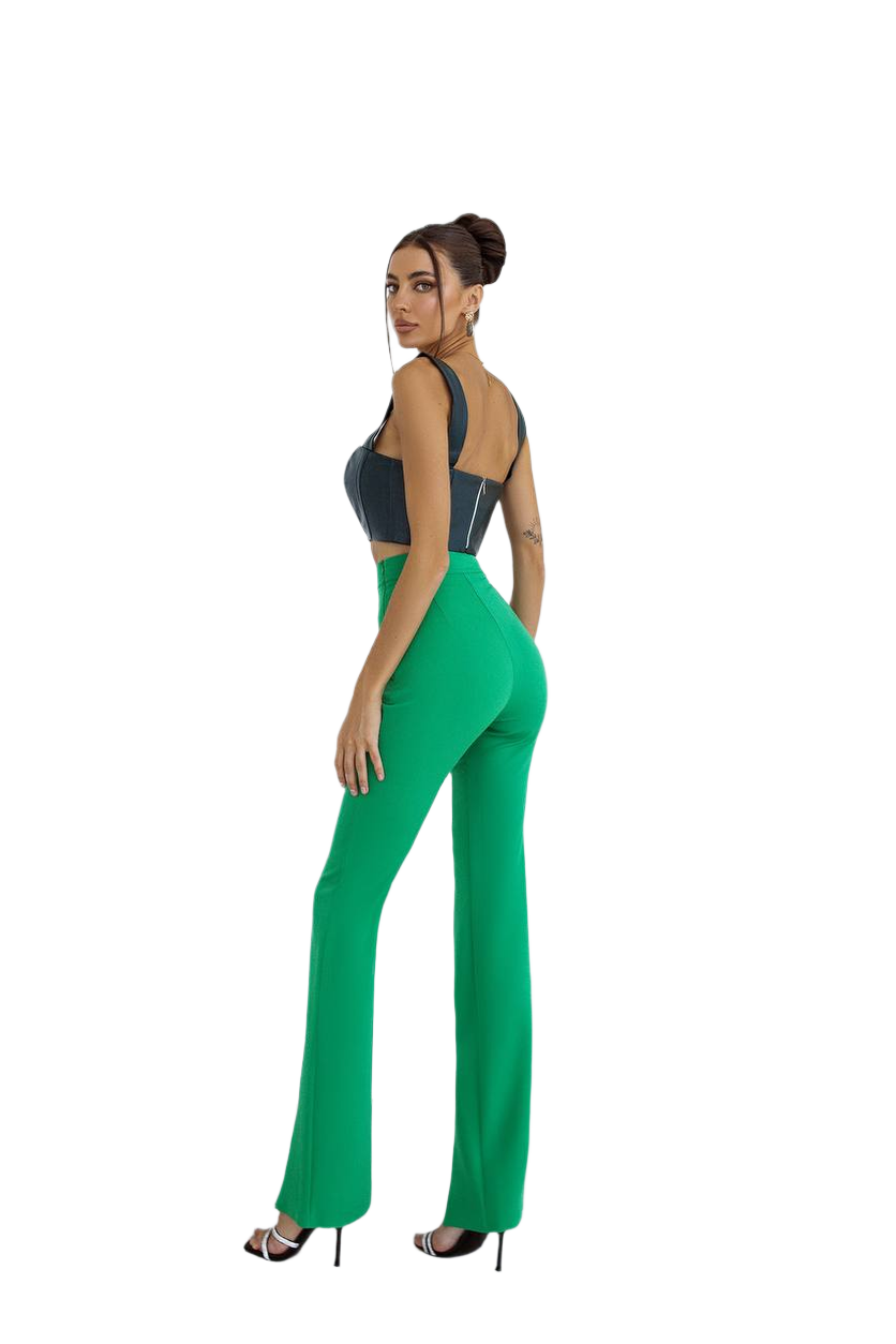 Woman wearing a black top and green pants on a white background