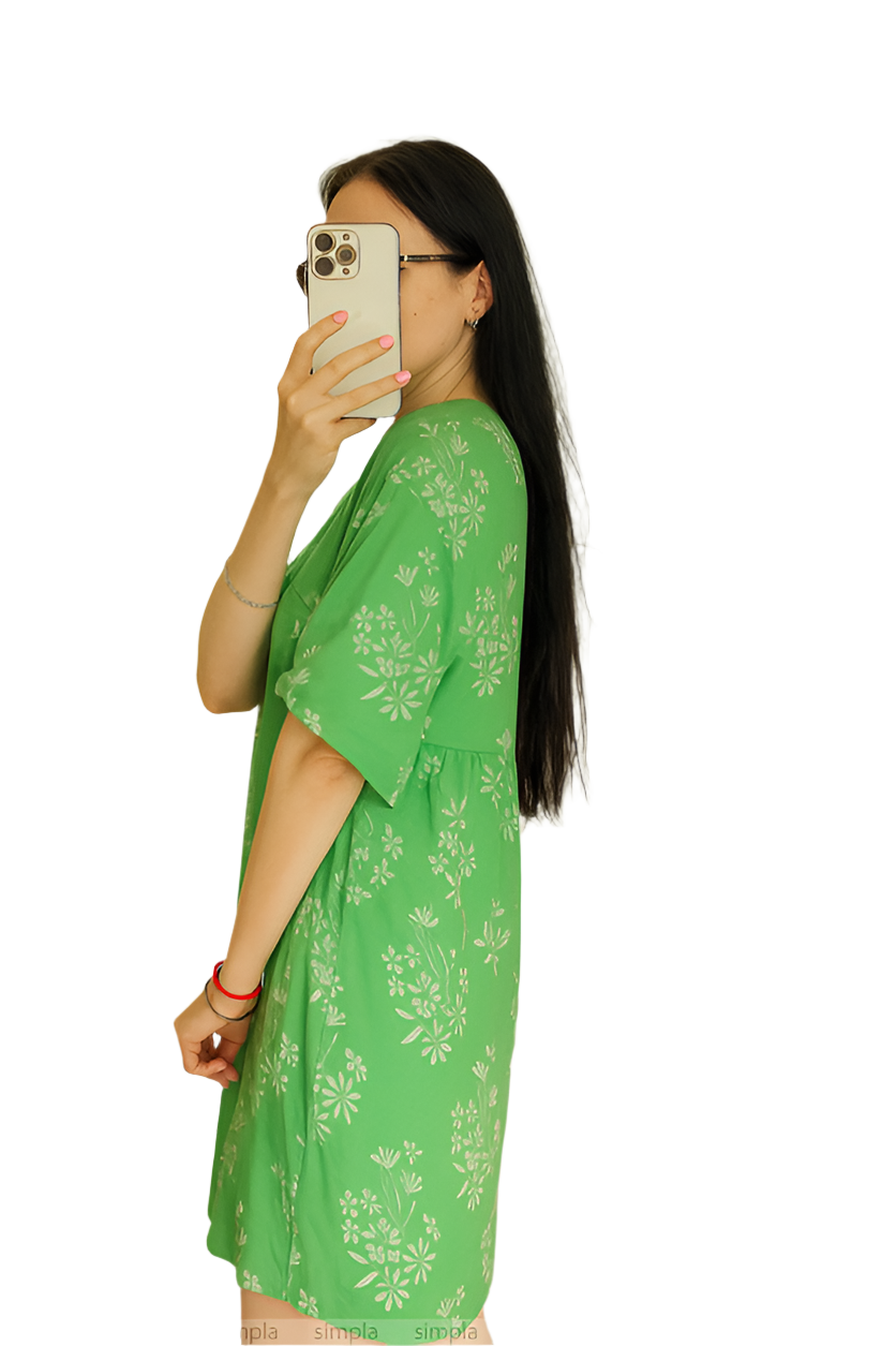 Woman wearing a green floral dress against a white background
