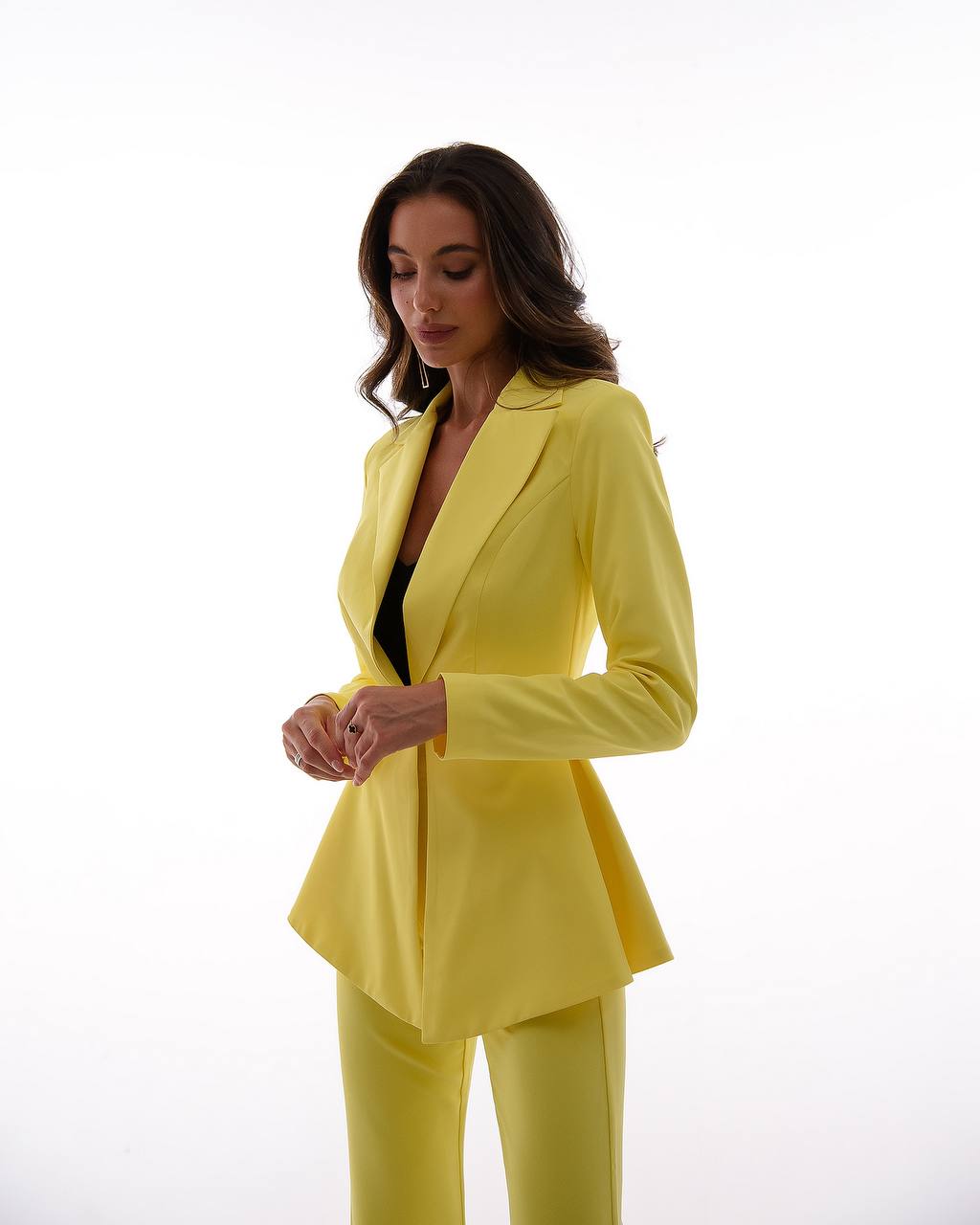 Woman wearing a bright yellow suit on a white background