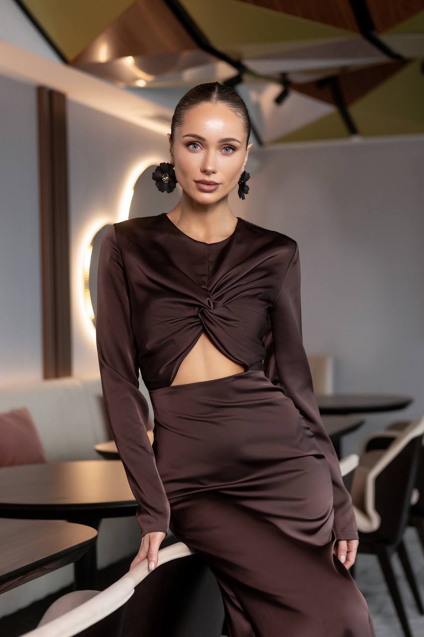 Woman in a brown outfit sitting in a modern restaurant setting
