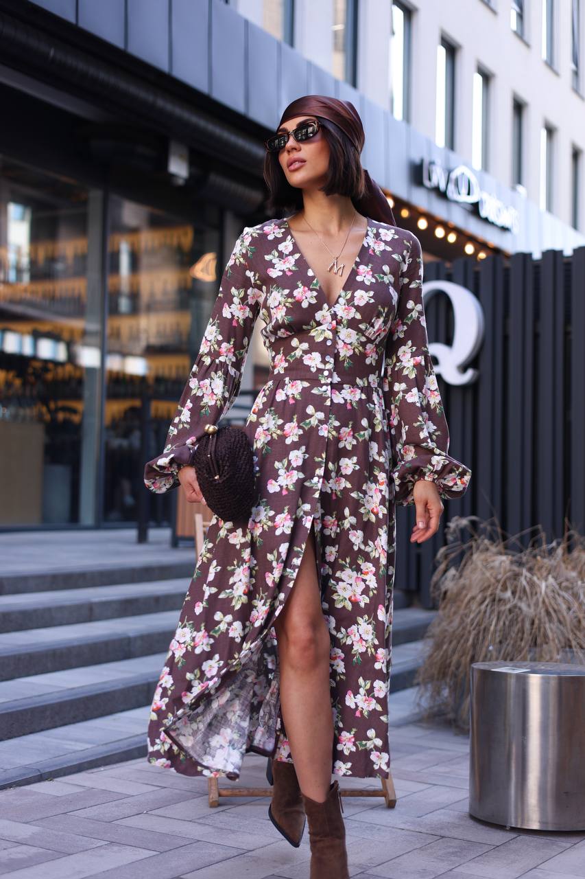 Woman in a floral dress walking outdoors with a building in the background