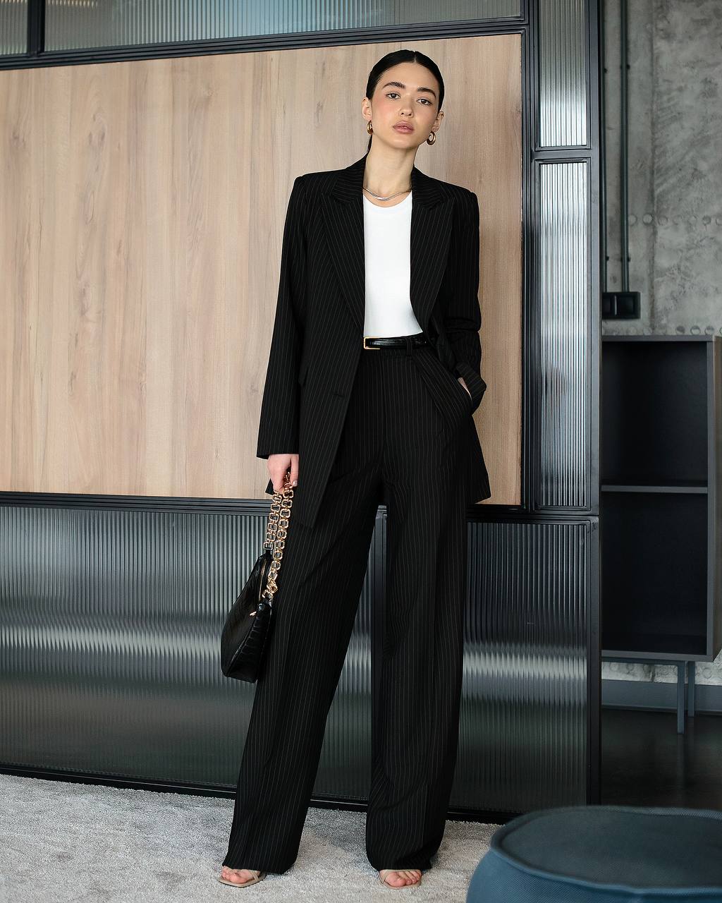 Woman in a black suit standing in an office setting