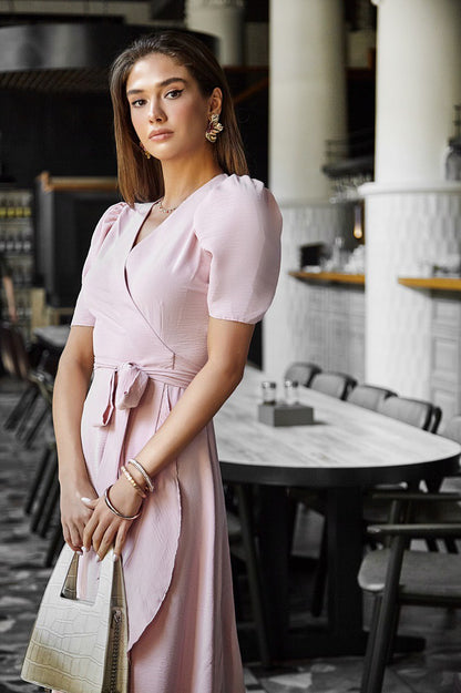 Woman in a pink dress standing in a restaurant setting