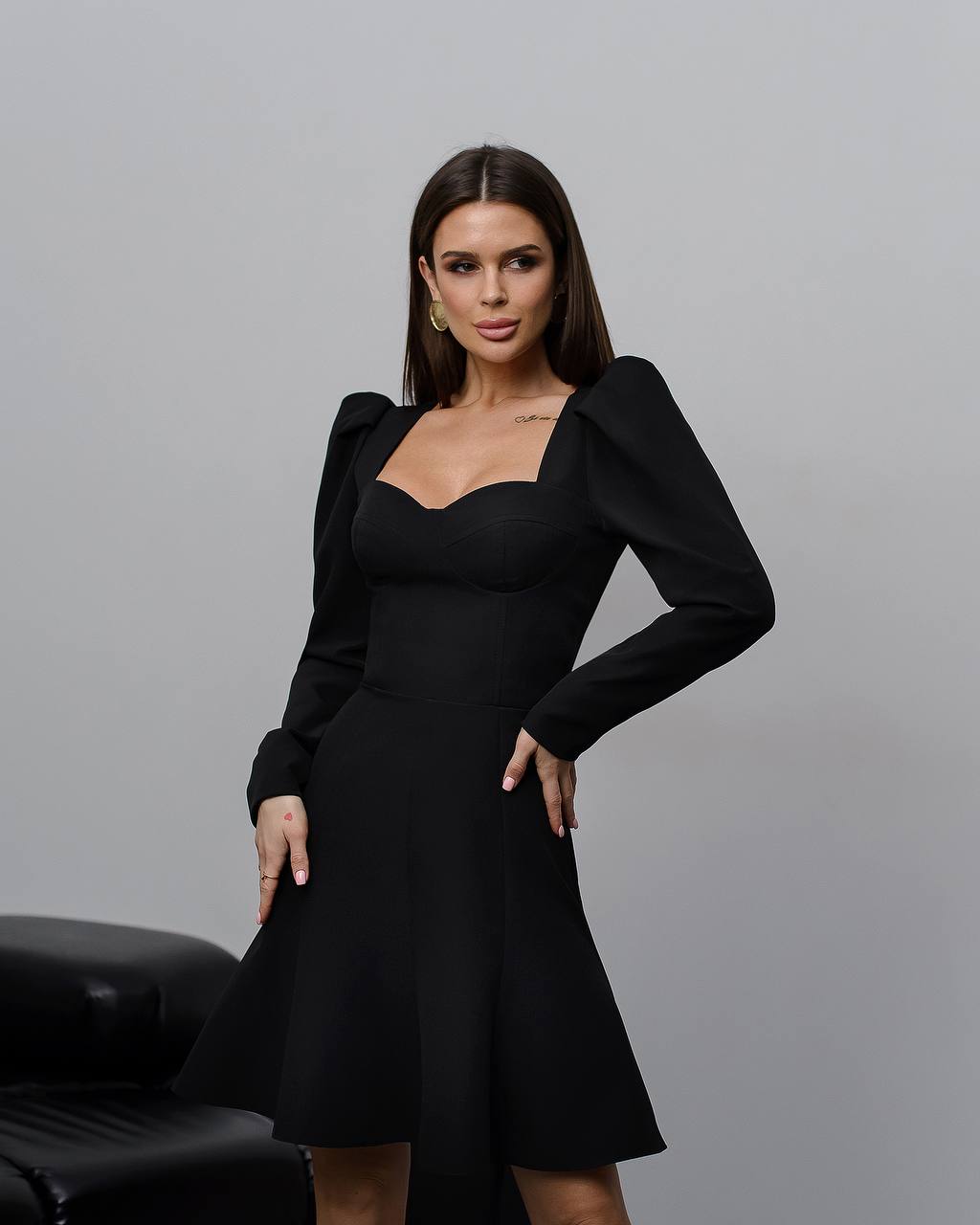 Woman wearing a black dress with a gray background