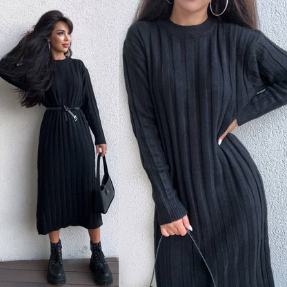 Woman wearing a black ribbed dress against a white wall.