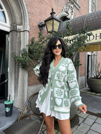 Woman wearing a green and white patterned cardigan in an urban setting.
